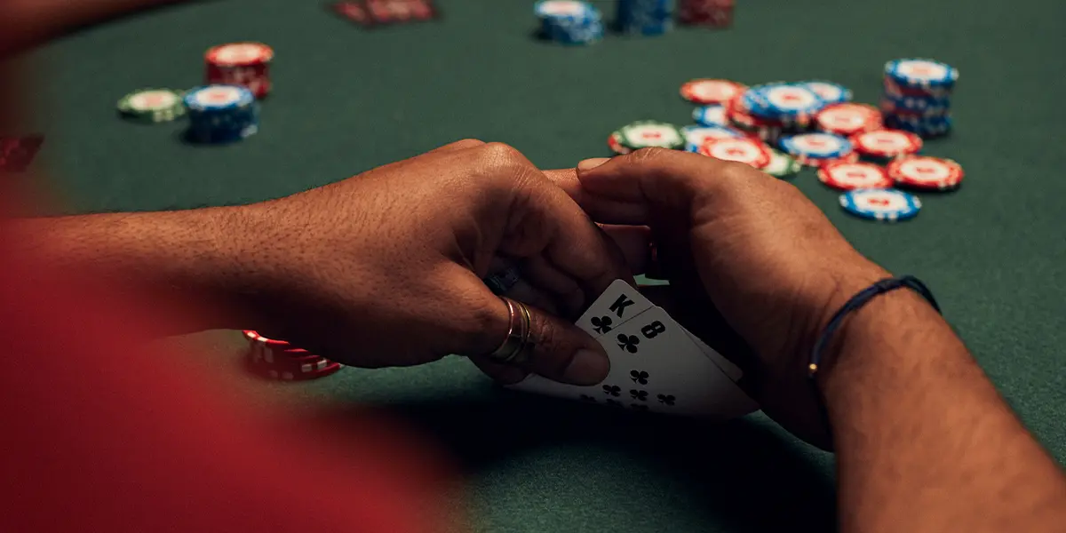 Un joueur de poker détient K8 assortis, une situation risquée en début de tournoi.