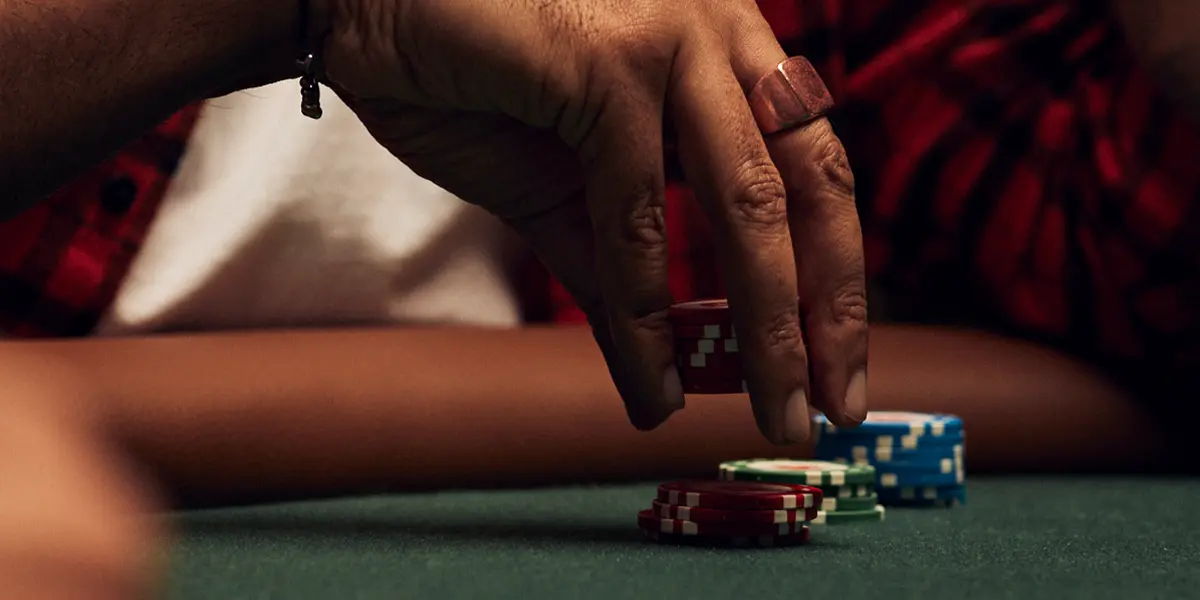 Main tendue vers les jetons — représentant un 3-bet agressif dans une partie de cash game.